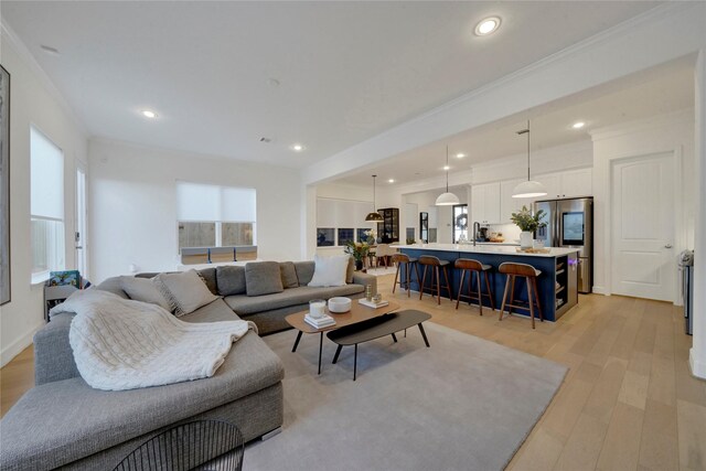 living room featuring ornamental molding and light hardwood / wood-style flooring