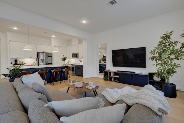 living room with ornamental molding and light hardwood / wood-style flooring