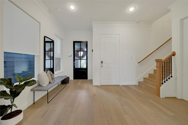 foyer featuring ornamental molding and light hardwood / wood-style flooring