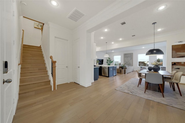 dining area featuring crown molding and light hardwood / wood-style flooring