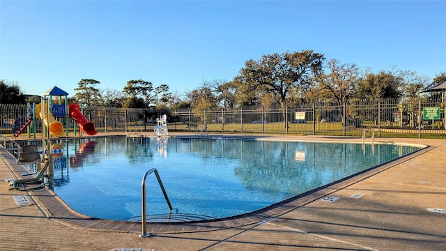 view of swimming pool with a playground