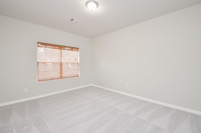 unfurnished room with visible vents, baseboards, and light colored carpet