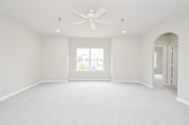 unfurnished room with arched walkways, recessed lighting, visible vents, and baseboards