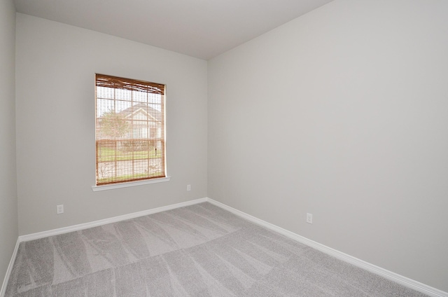 carpeted spare room with baseboards