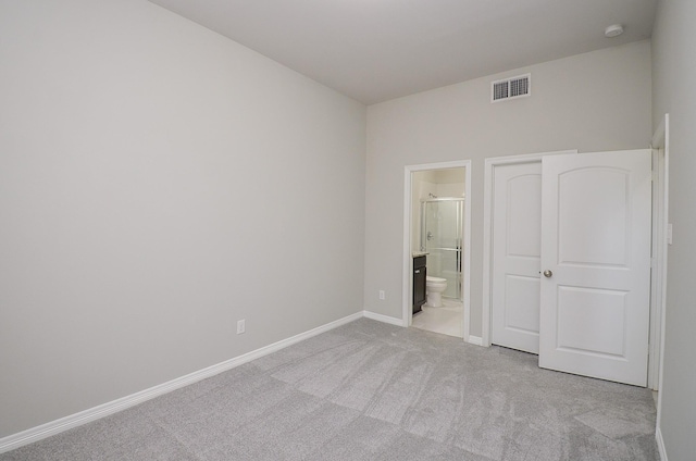 unfurnished bedroom featuring light carpet, baseboards, visible vents, and connected bathroom