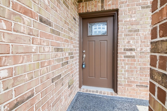 property entrance featuring brick siding