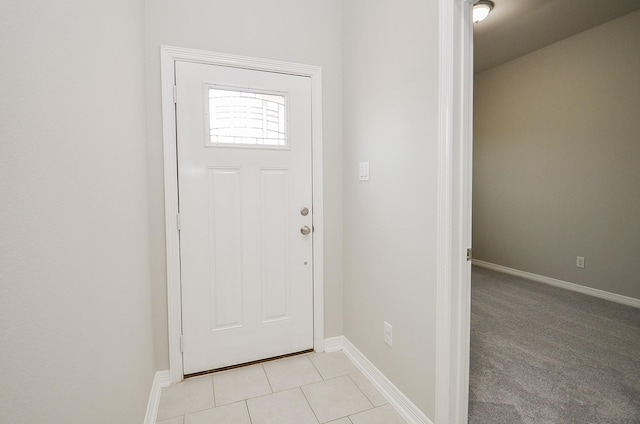 doorway with baseboards and light tile patterned floors