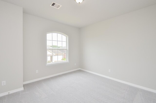 empty room featuring carpet floors, visible vents, and baseboards