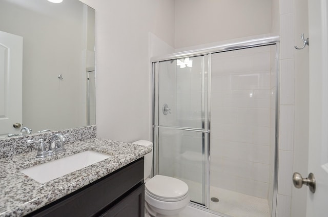 full bathroom with a stall shower, vanity, and toilet