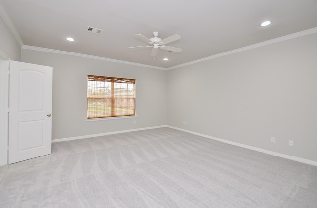 spare room with ornamental molding, light colored carpet, visible vents, and baseboards