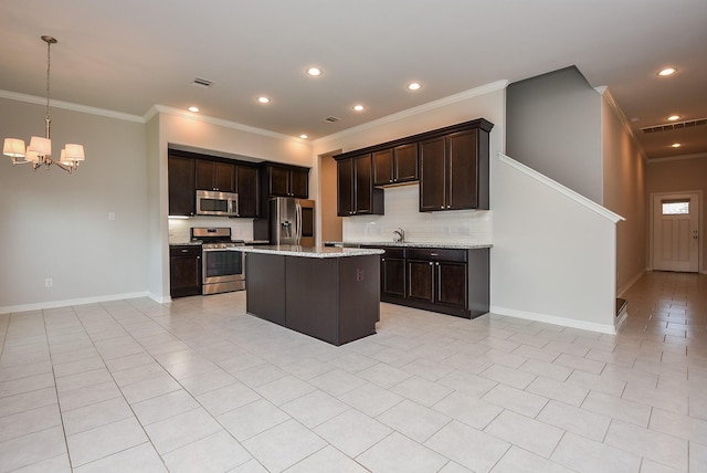 kitchen with dark brown cabinetry, appliances with stainless steel finishes, a center island, a notable chandelier, and light tile patterned flooring