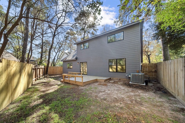 back of house with central air condition unit and a deck