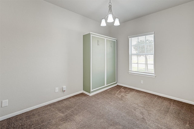 unfurnished bedroom with carpet flooring and a notable chandelier