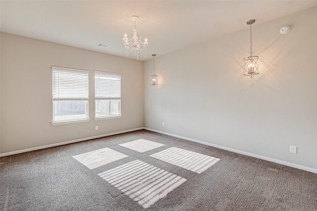 empty room with carpet floors and a notable chandelier