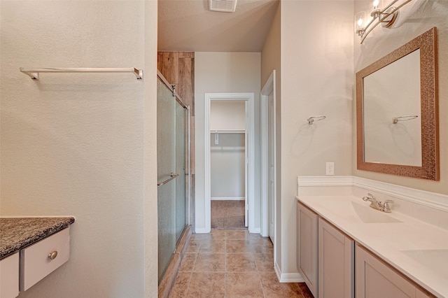 bathroom with vanity, tile patterned floors, and walk in shower