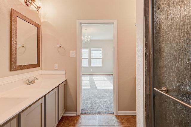 bathroom with tile patterned floors, vanity, and an inviting chandelier