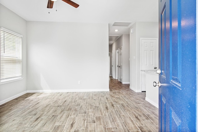 empty room featuring baseboards, visible vents, light wood-style flooring, and a ceiling fan