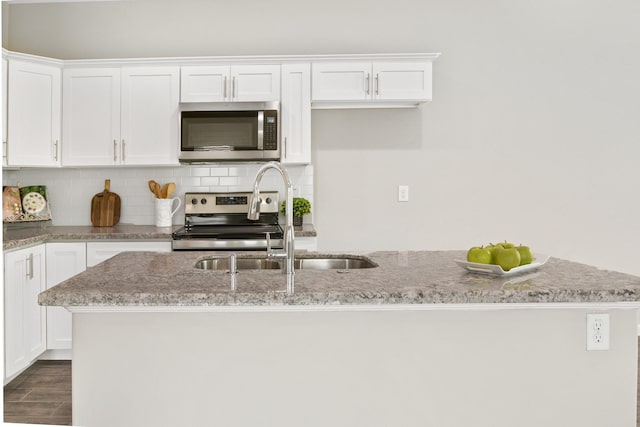 4649 Carmen St, Houston, TX 77051 - kitchen with stainless steel appliances, a sink, white cabinets, and decorative backsplash