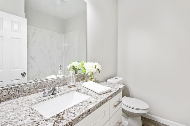 bathroom with vanity, wood-type flooring, and toilet