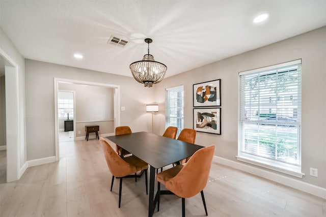 dining room featuring a notable chandelier and light hardwood / wood-style flooring