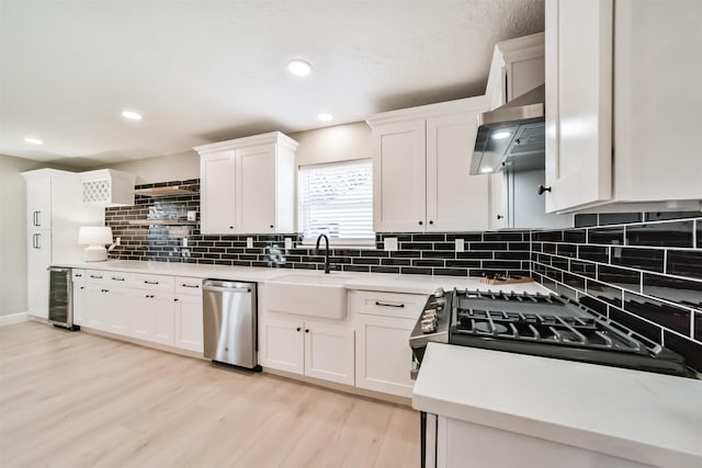 kitchen with wine cooler, ventilation hood, stainless steel dishwasher, and white cabinetry