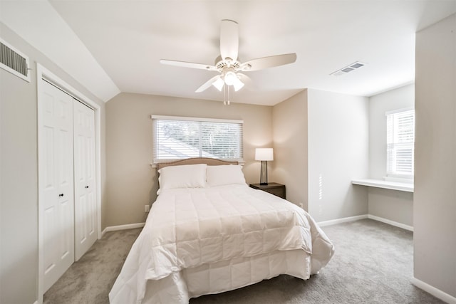 bedroom with ceiling fan, light colored carpet, and vaulted ceiling