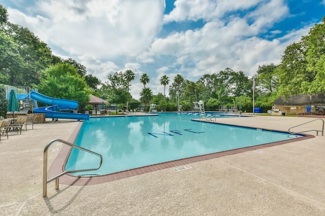 view of swimming pool with a patio and a water slide