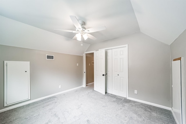 unfurnished bedroom with light carpet, a closet, ceiling fan, and lofted ceiling