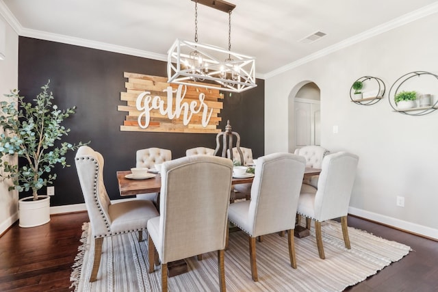 dining room with a chandelier, dark hardwood / wood-style flooring, and crown molding