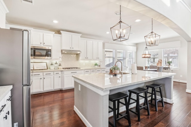 kitchen featuring stainless steel appliances, sink, pendant lighting, a center island with sink, and white cabinetry