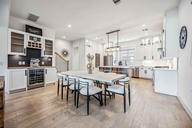 dining space featuring light hardwood / wood-style floors and beverage cooler