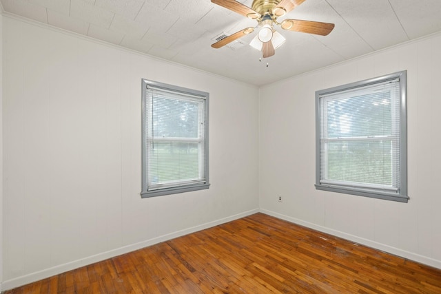 empty room featuring ornamental molding, ceiling fan, and dark wood-type flooring