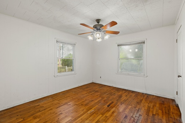 unfurnished room with ceiling fan and dark wood-type flooring