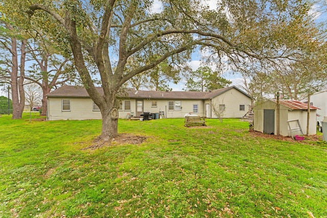 rear view of property with a yard and a storage shed