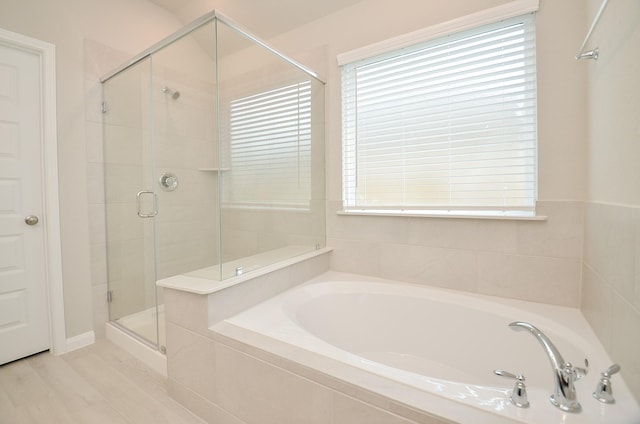 bathroom with separate shower and tub and wood-type flooring