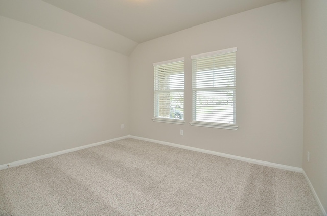 unfurnished room featuring carpet flooring and vaulted ceiling