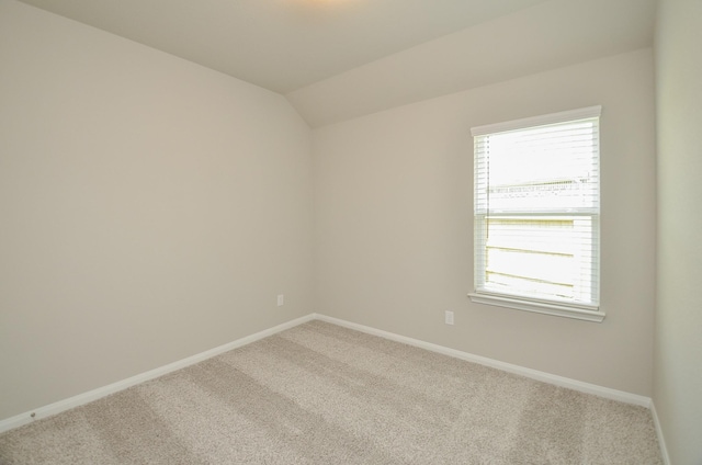 unfurnished room with carpet floors and vaulted ceiling