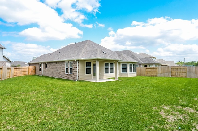 rear view of house with a yard and a patio