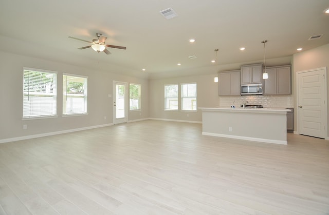 unfurnished living room featuring light hardwood / wood-style flooring and ceiling fan