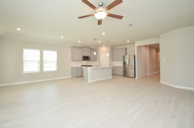 unfurnished living room featuring ceiling fan, light hardwood / wood-style flooring, and sink