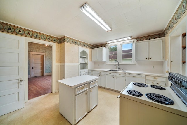 kitchen with white cabinetry, a center island, white appliances, and sink