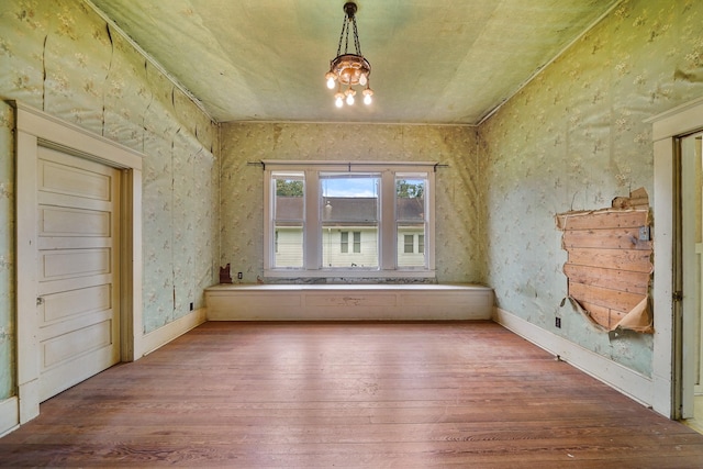 unfurnished room featuring hardwood / wood-style flooring and a notable chandelier