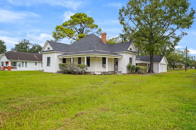 view of front of home with an outbuilding, a porch, a garage, and a front lawn