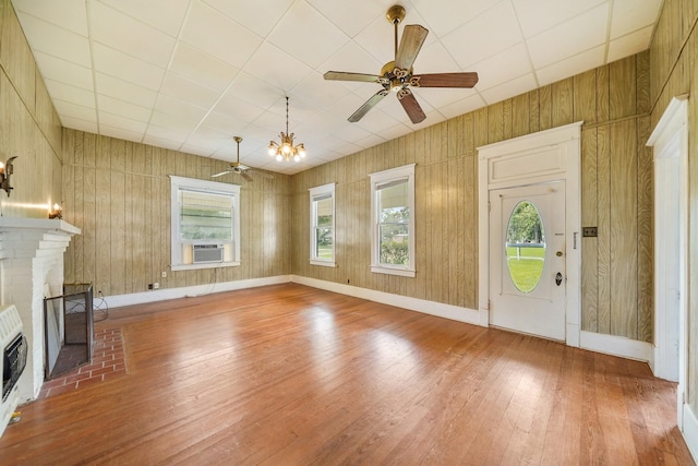 entrance foyer with hardwood / wood-style flooring, ceiling fan with notable chandelier, cooling unit, and a fireplace