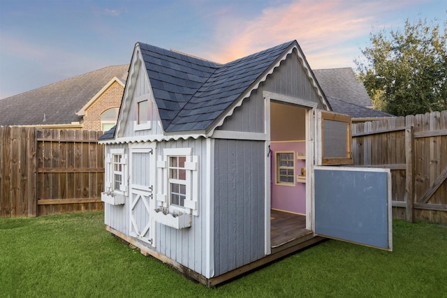 outdoor structure at dusk featuring a yard