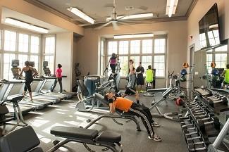 workout area featuring ceiling fan and ornamental molding