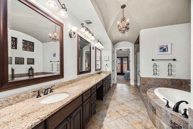 bathroom featuring ceiling fan with notable chandelier, vanity, plus walk in shower, and vaulted ceiling