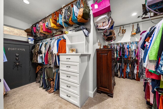 walk in closet with light colored carpet