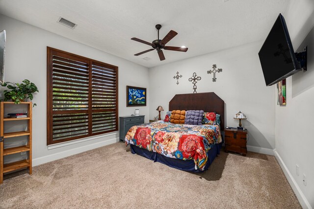 bedroom with ceiling fan, carpet, and a textured ceiling