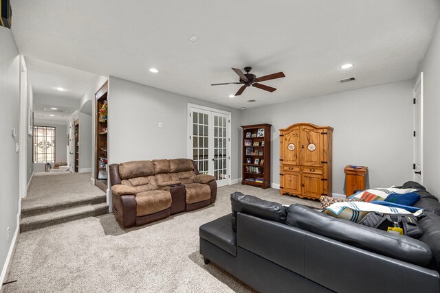 carpeted living room with ceiling fan and french doors